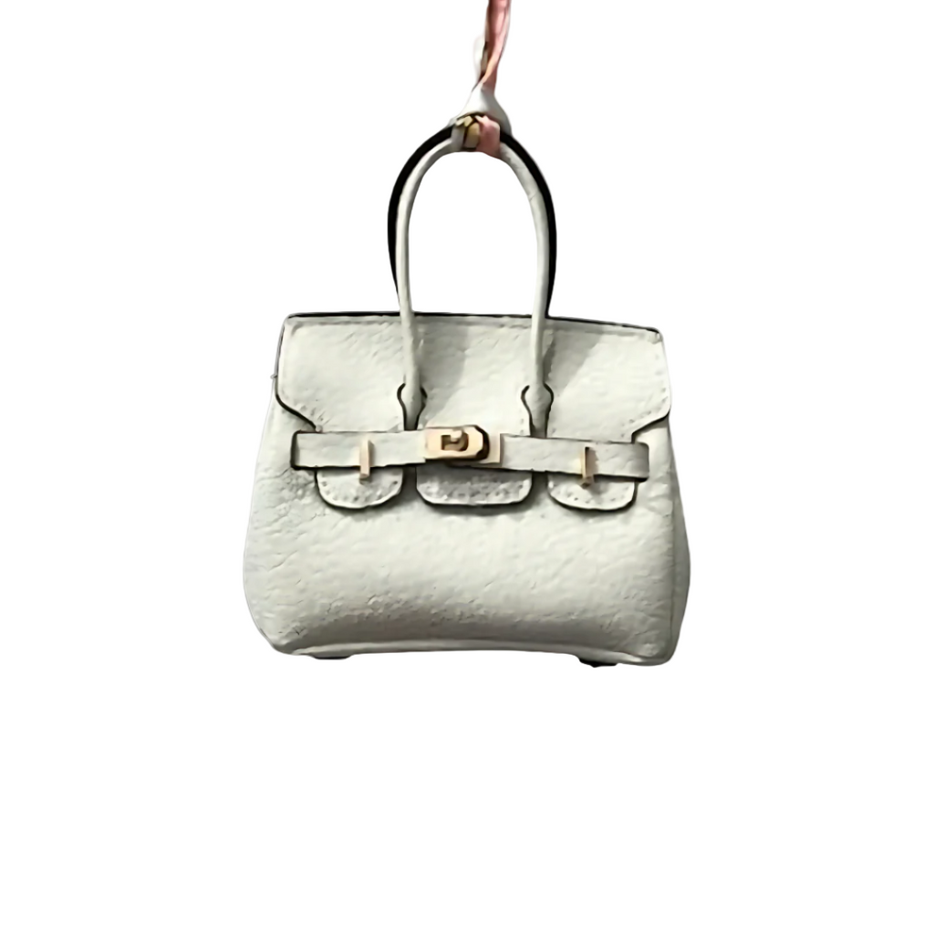 White genuine leather Mini Purse Iconic Bag Charm with structured shape, top handle, securing straps, and gold-tone padlock.