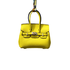 Yellow genuine leather Mini Purse Iconic Bag Charm with structured shape, top handle, securing straps, and gold-tone padlock.