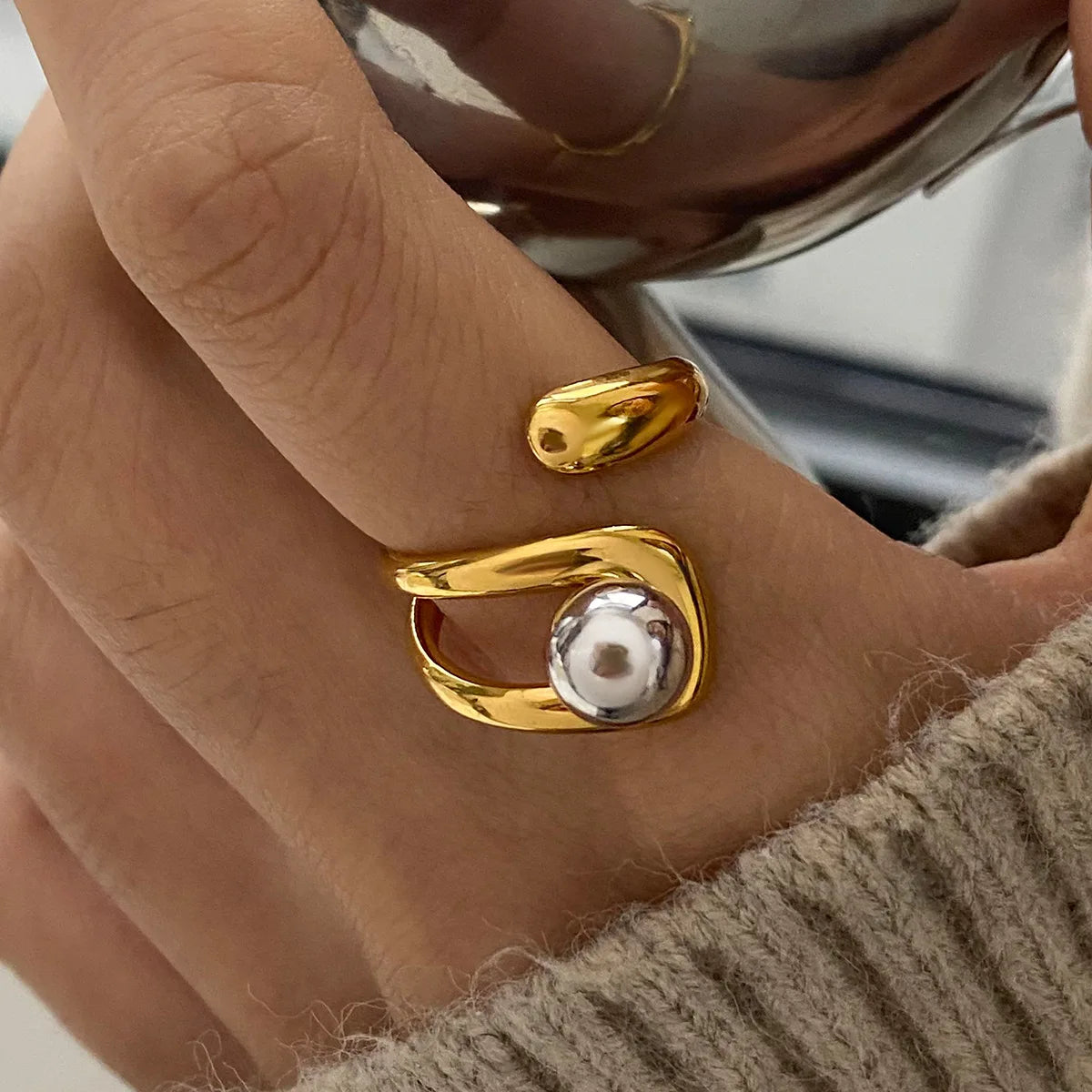 Gold ring with a pearl on a person's finger