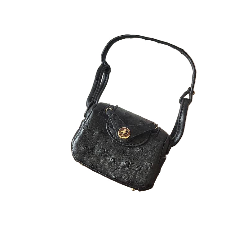 Black Ostrich textured mini bag charm with flap closure and small shoulder strap.