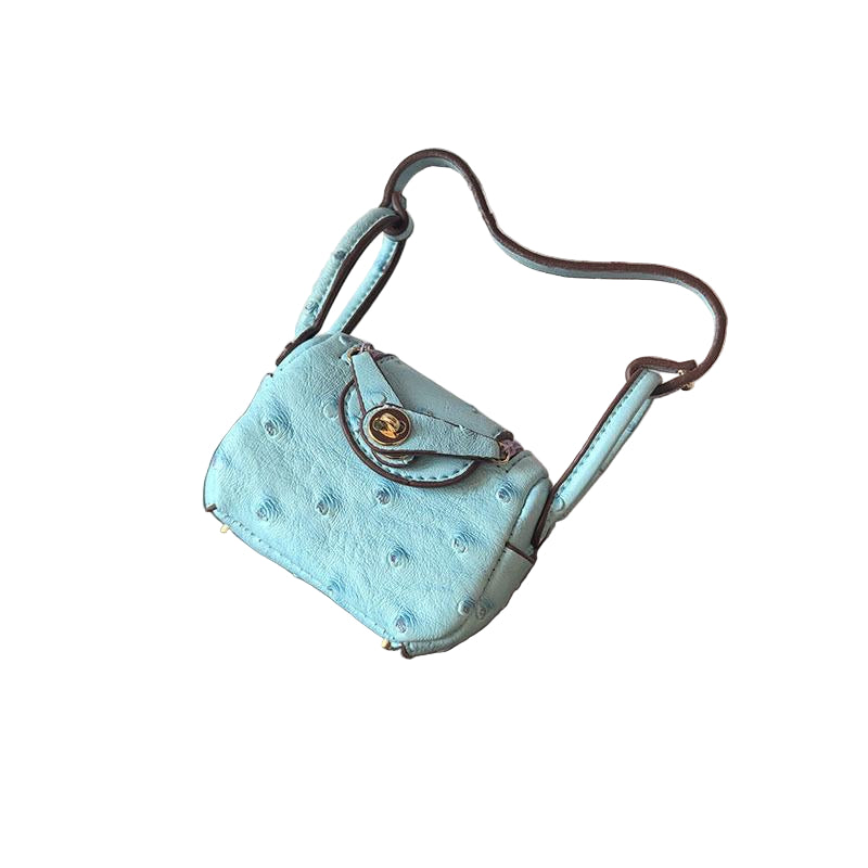 Very light blue Ostrich textured mini bag charm with flap closure and small shoulder strap.