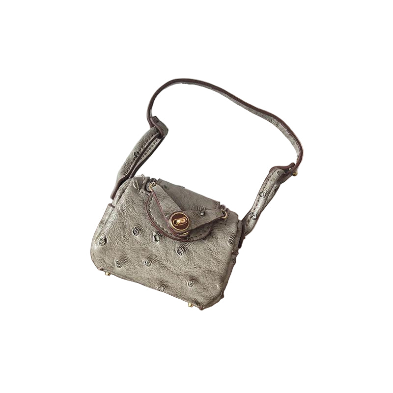 Warm gray Ostrich textured mini bag charm with flap closure and small shoulder strap.