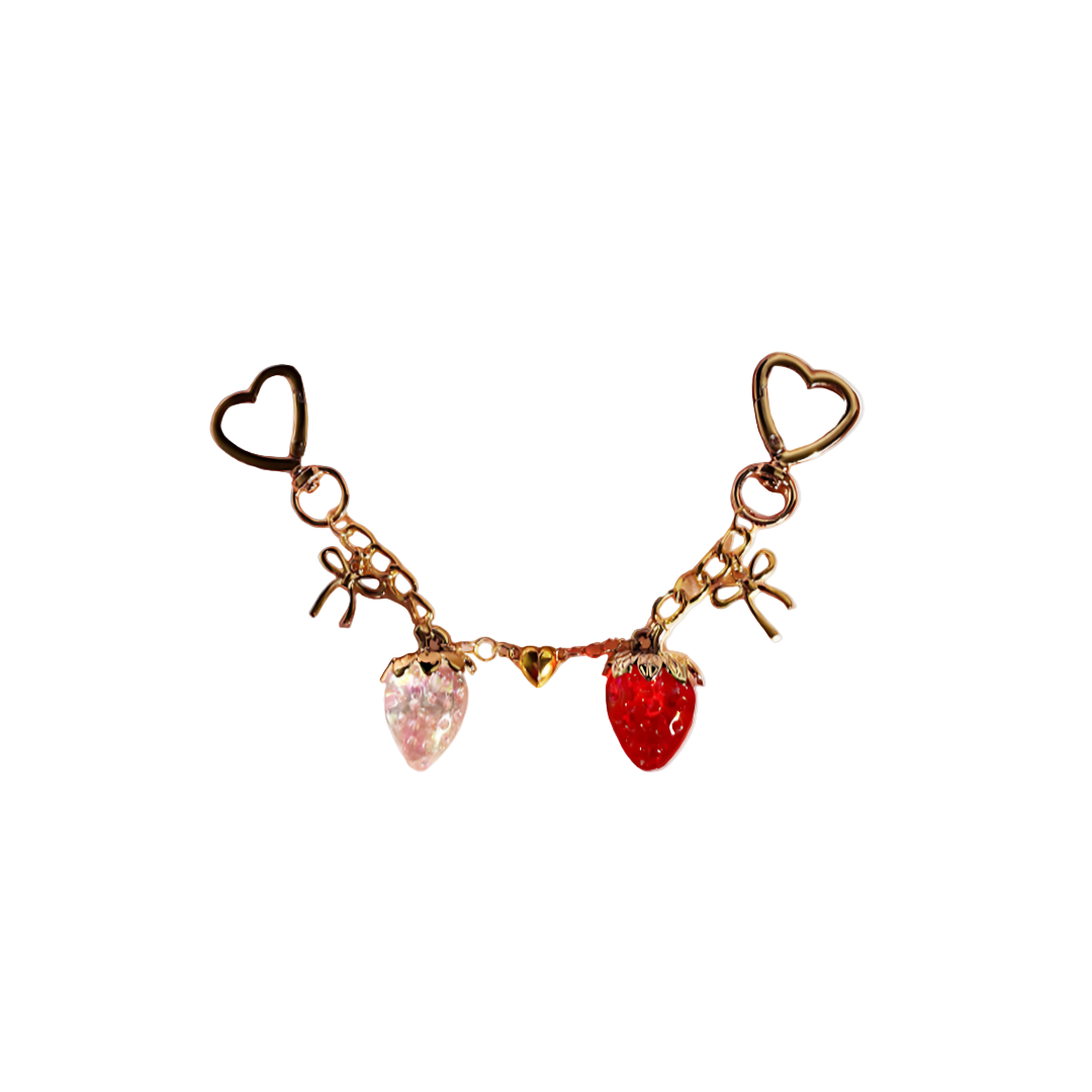 Gold-tone paired keychain set featuring one glitter pink strawberry charm and one clear red strawberry charm, connected by a heart accent and attached to heart-shaped keyrings.