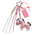 Pink donkey-shaped keychain with various straps on a newspaper background