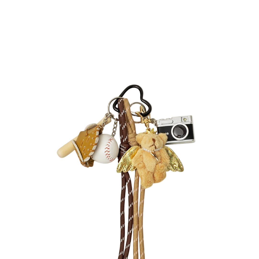 Tan plush teddy bear bag charm with gold wings (angel), baseball, baseball bat, and camera components hanging from a keychain.
