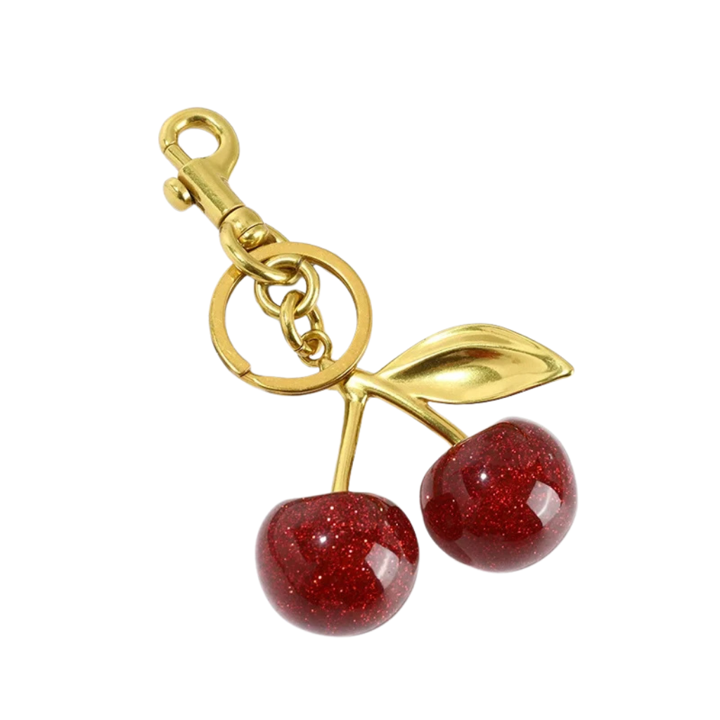 Gold keychain with red cherry charms on a white background. Charm for backpack, bags, zipper or other things. 