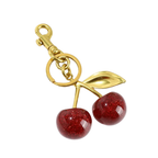 Gold keychain with red cherry charms on a white background. Charm for backpack, bags, zipper or other things. 