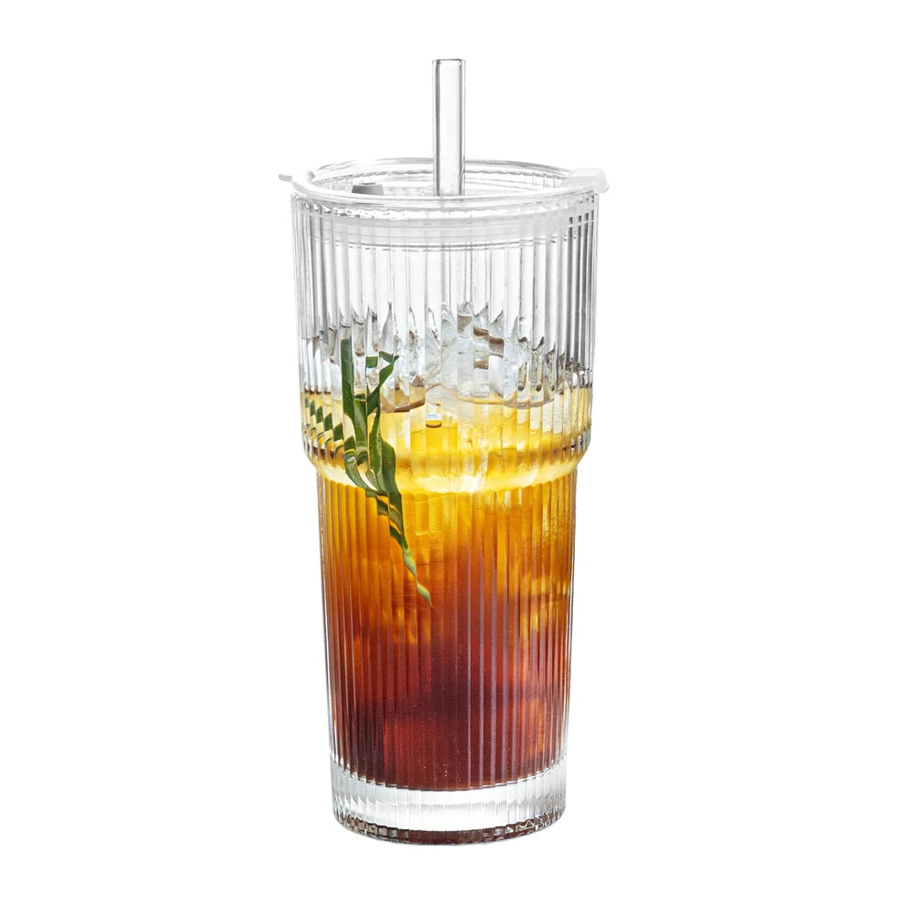Clear glass with a layered drink, straw, and garnish on a white background