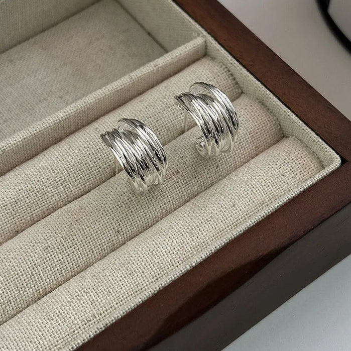 Silver hoop earrings in a jewelry box with beige interior
