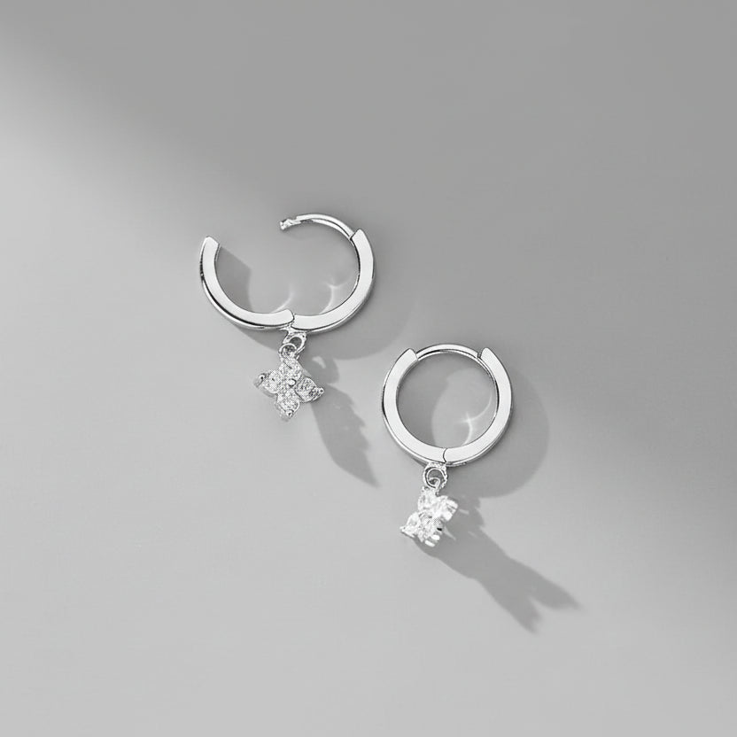 Silver hoop earrings with star-shaped charms on a pink background, featuring 'SHEIN SILVER JEWELRY' branding.