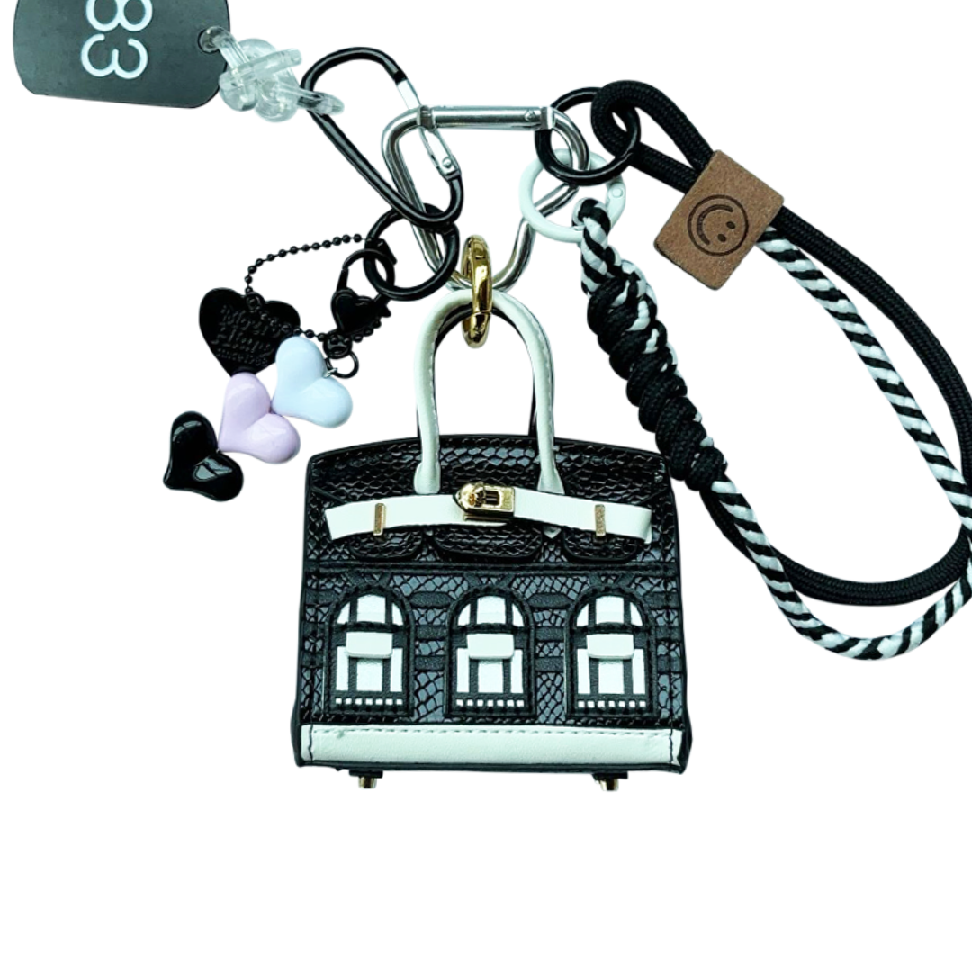 Black snakeskin leather mini bag charm shaped like a house, featuring window panels and a top handle.