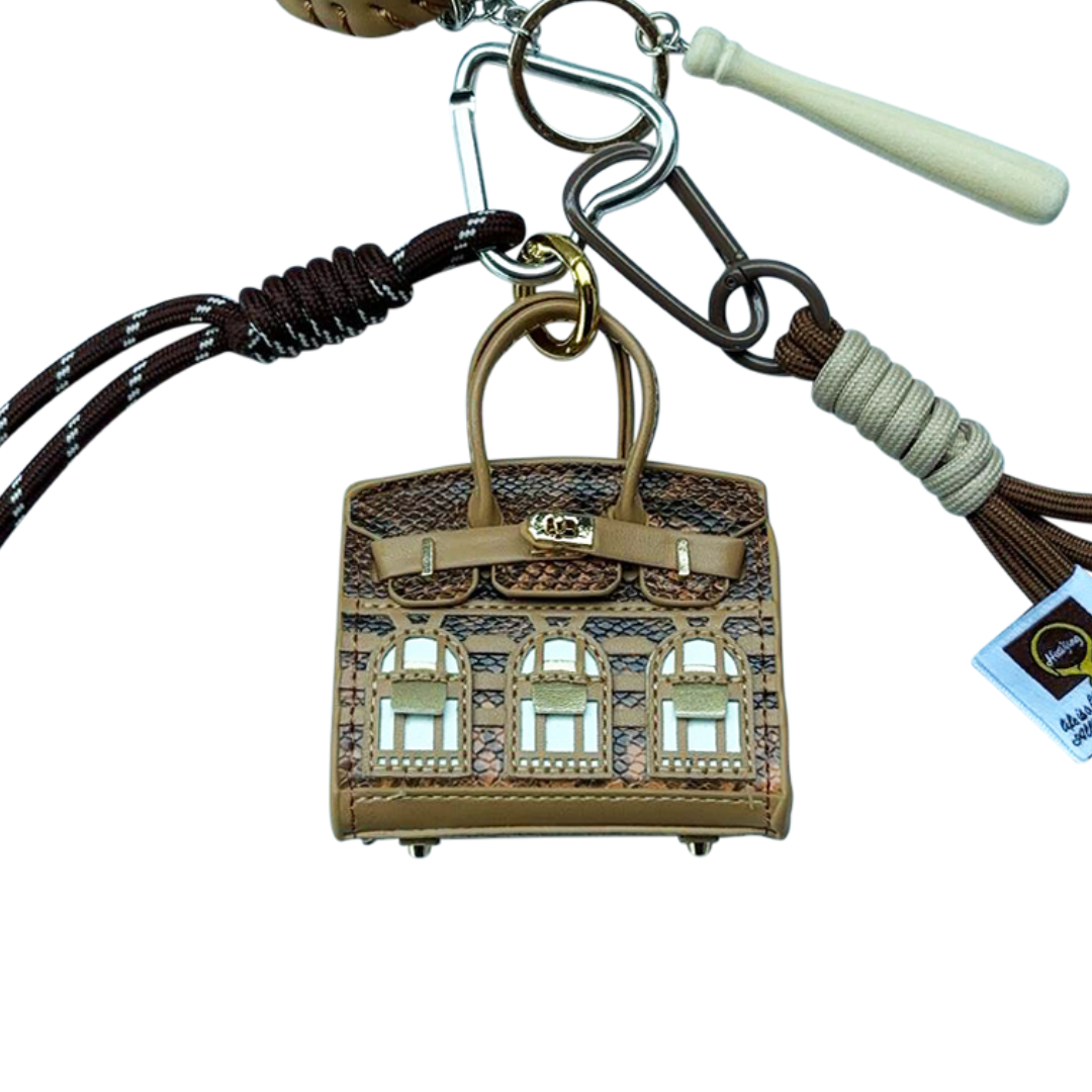 Brown snakeskin leather mini bag charm with keychain shaped like a house, featuring window panels and a top handle.