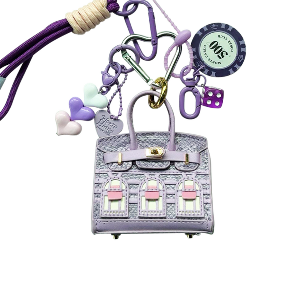 Lavender snakeskin leather mini bag charm shaped like a house, featuring a keychain and window panels and a top handle.