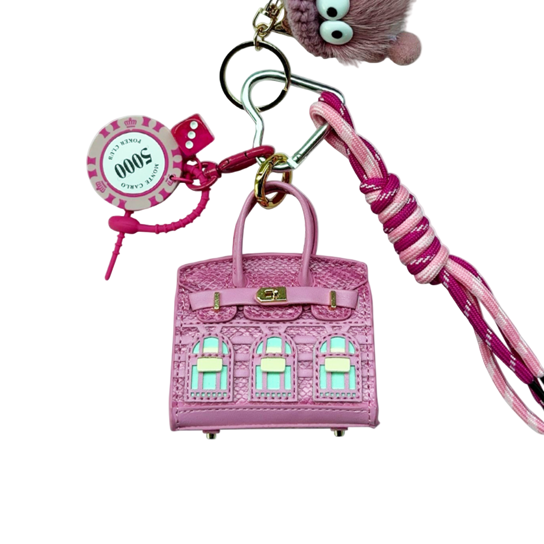 Pink snakeskin leather mini bag charm shaped like a house, featuring window panels and a top handle.