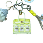 Yellow snakeskin leather mini bag charm with keychain shaped like a house, featuring window panels and a top handle.