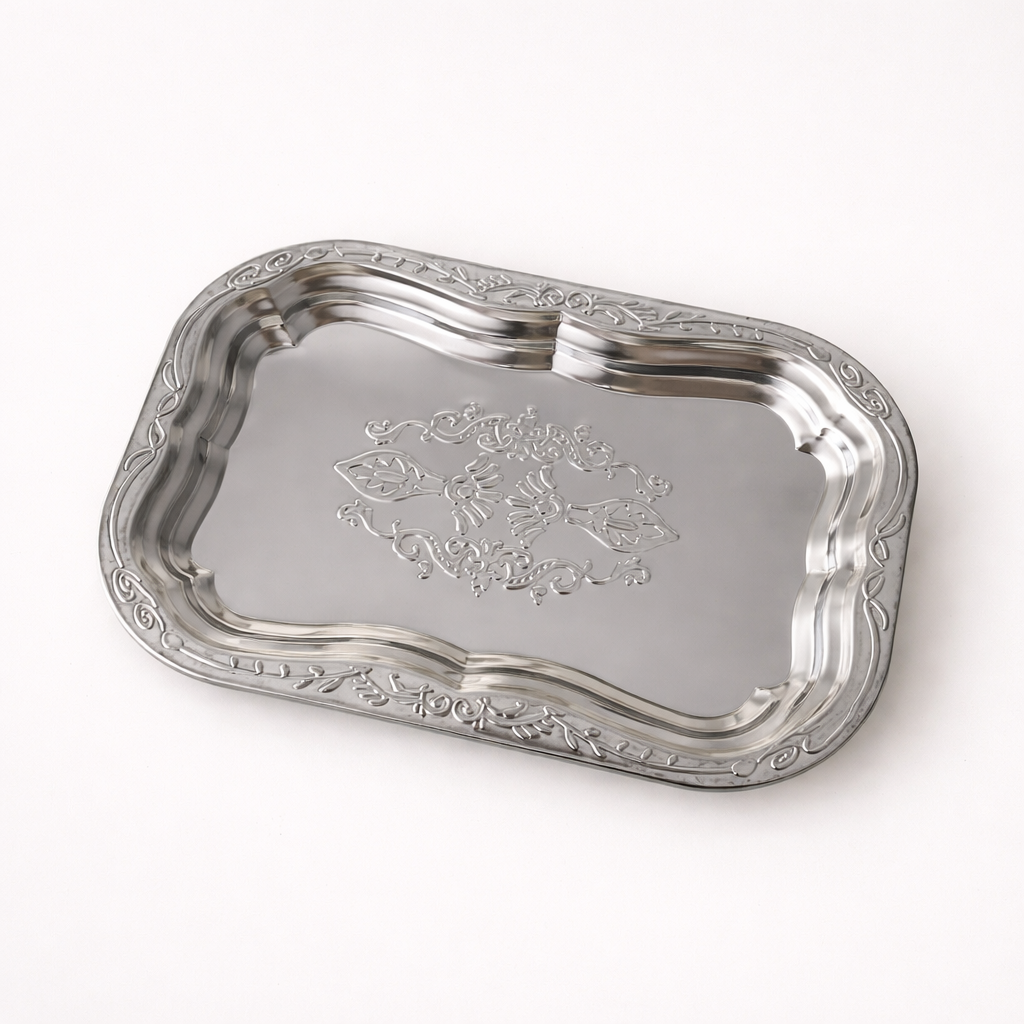 Silver tray with intricate designs on a white background