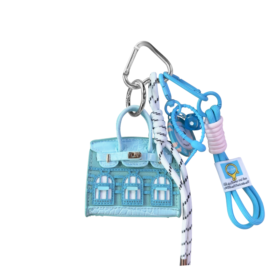 Light blue house mini bag charm keychain with matching lanyard on a white background