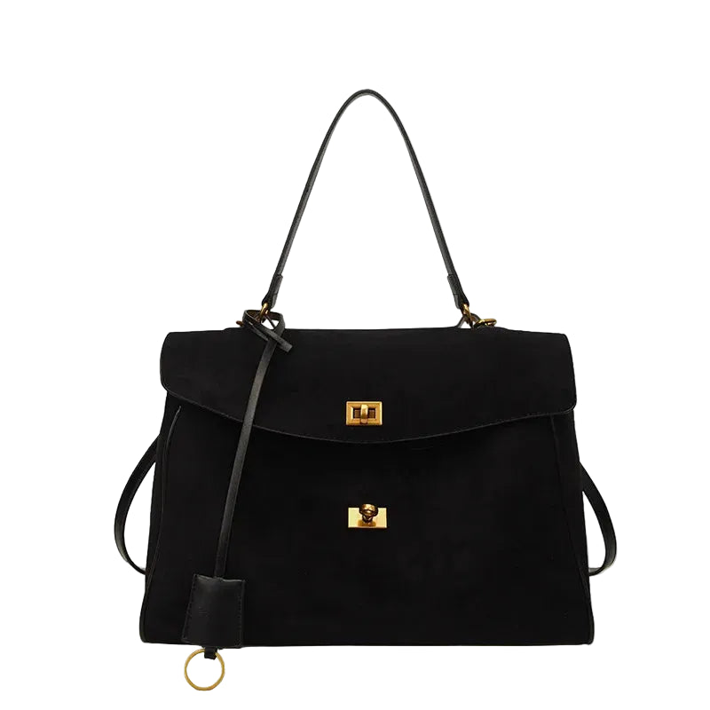 Black suede handbag with gold accents on a white background.