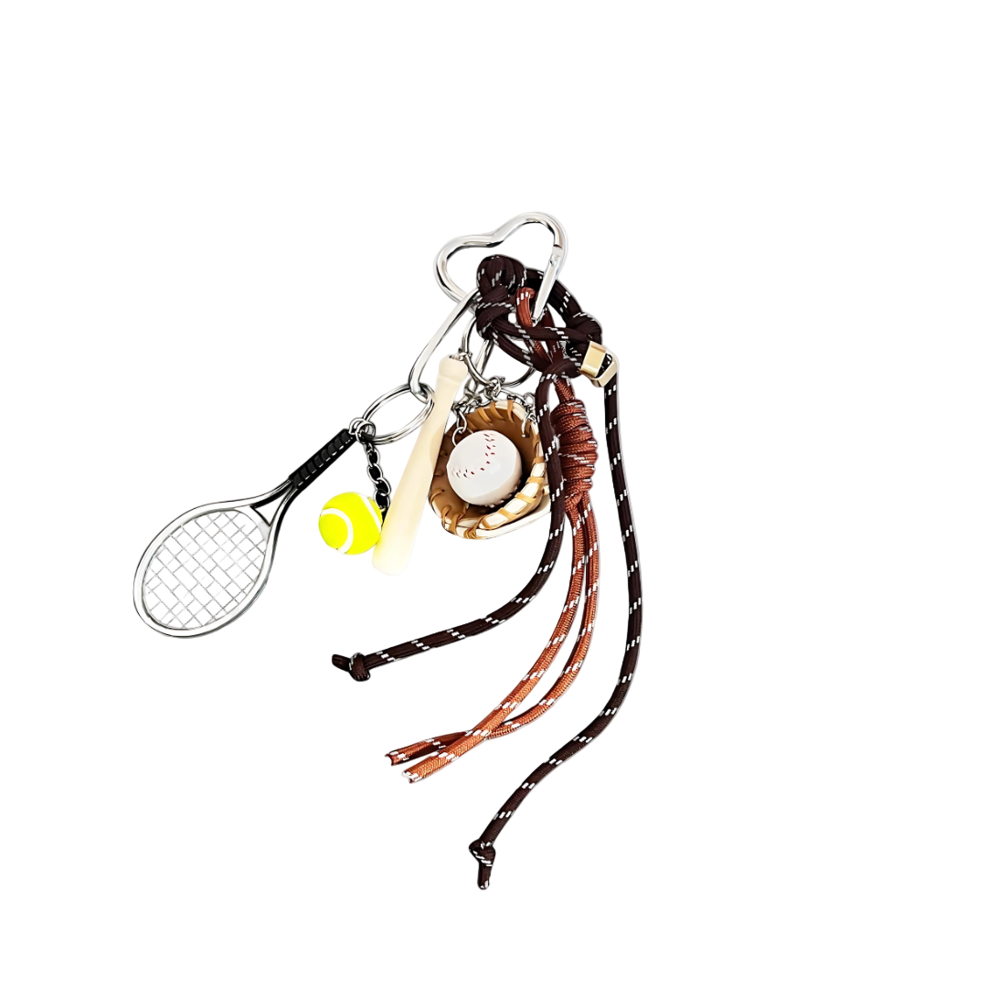 A handbag charm featuring a tennis racket, a tennis ball, a watch, and other accessories against a white background.