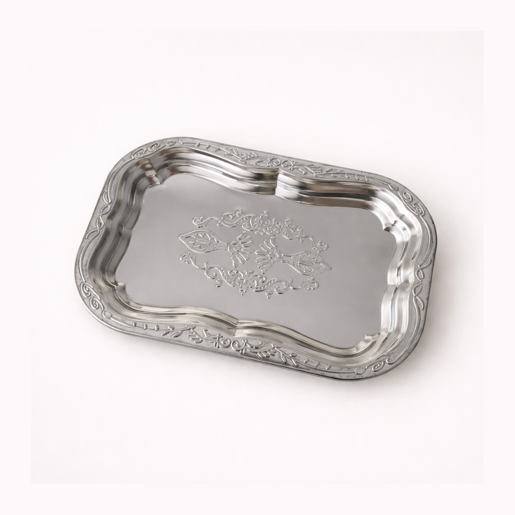 Silver tray with intricate designs on a white background