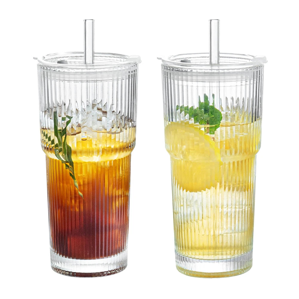 Two glasses with striped design filled with iced drinks, one with a lemon slice and mint leaf, on a white background.